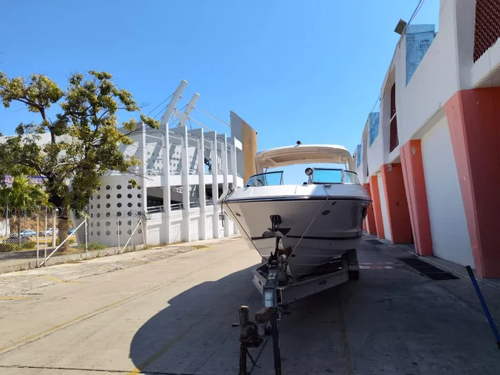 2018 Sea Ray 350 Slx @ Acapulco Yacht Photos Pics 2018 Sea Ray SLX 350 boat on trailer near modern building and trees.