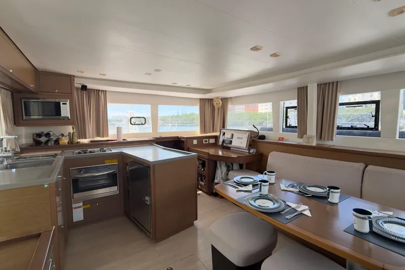 Carpediem 2 Yacht Photos Pics 2019 Lagoon 450 yacht interior with modern kitchen and dining area, featuring elegant table settings.
