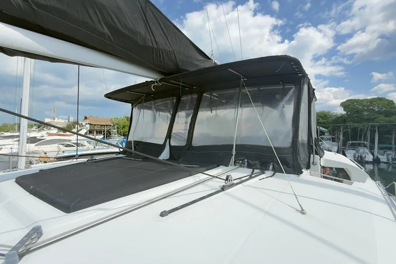 Carpediem 2 Yacht Photos Pics 2019 Lagoon 450 catamaran with black canopy, docked under a partly cloudy sky.