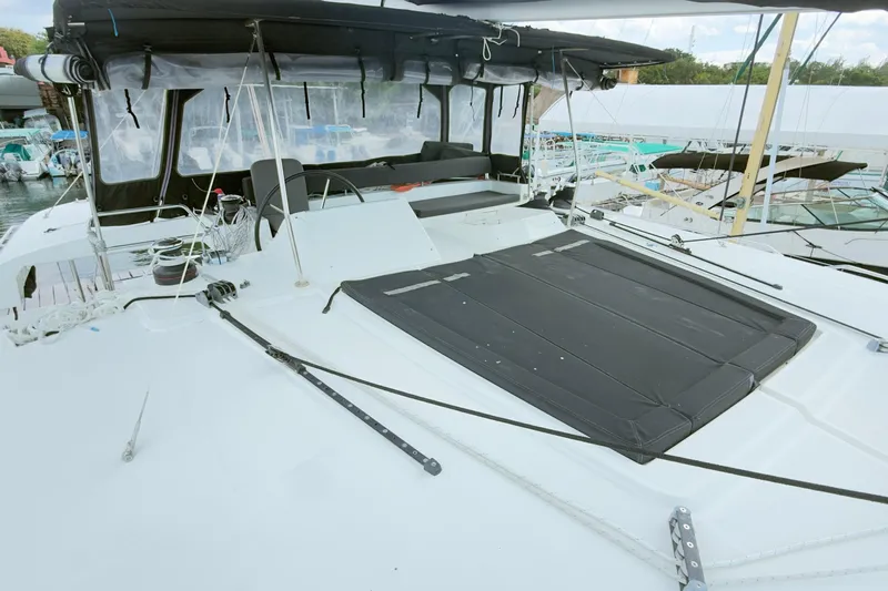 Carpediem 2 Yacht Photos Pics 2019 Lagoon 450 catamaran deck with seating and canopy in marina setting.
