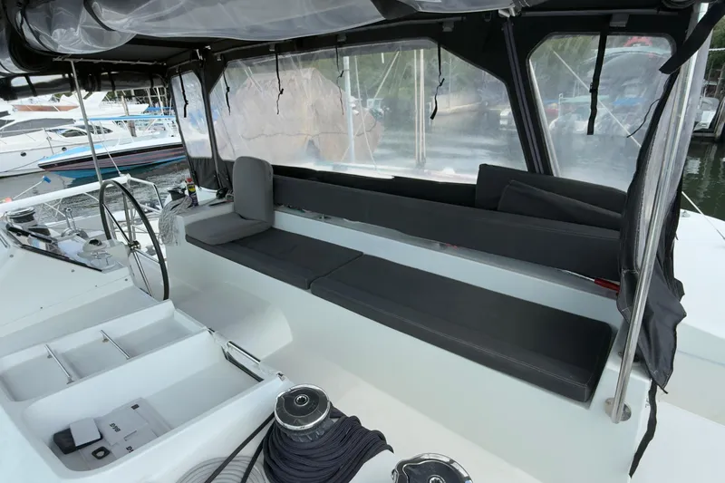 Carpediem 2 Yacht Photos Pics 2019 Lagoon 450 yacht cockpit with seating and steering wheel, docked at marina.