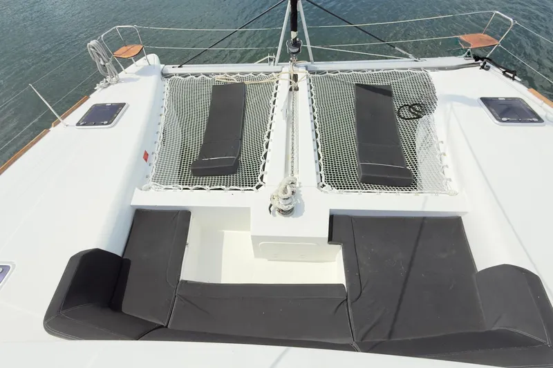 Carpediem 2 Yacht Photos Pics 2019 Lagoon 450 catamaran deck with netting and seating, overlooking water.