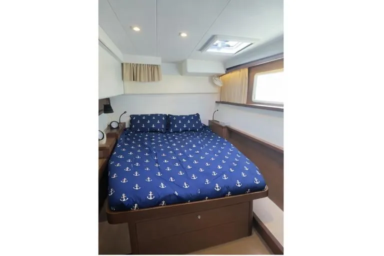Carpediem 2 Yacht Photos Pics Luxurious cabin interior of 2019 Lagoon 450 yacht with nautical-themed bedding.