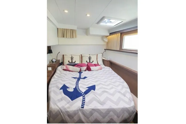 Carpediem 2 Yacht Photos Pics Luxurious bedroom in 2019 Lagoon 450 yacht with nautical-themed bedding and decor.