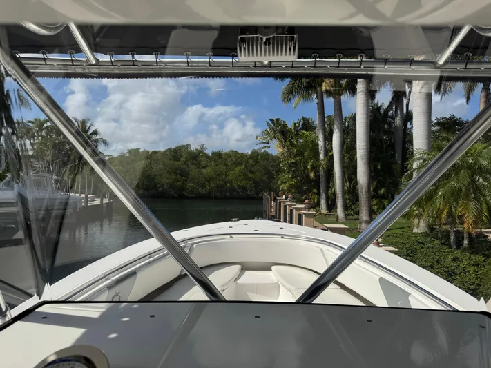  Yacht Photos Pics 2008 Fountain 34 Center Console boat docked near tropical palm trees and calm water.