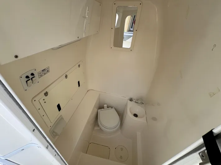  Yacht Photos Pics 2008 Fountain 34 Center Console boat interior with compact marine toilet and storage.