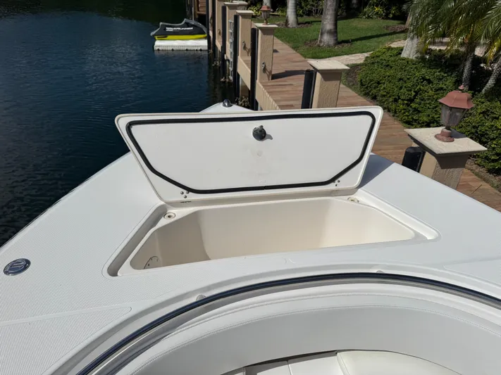  Yacht Photos Pics 2008 Fountain 34 Center Console boat with open storage compartment by a dock.
