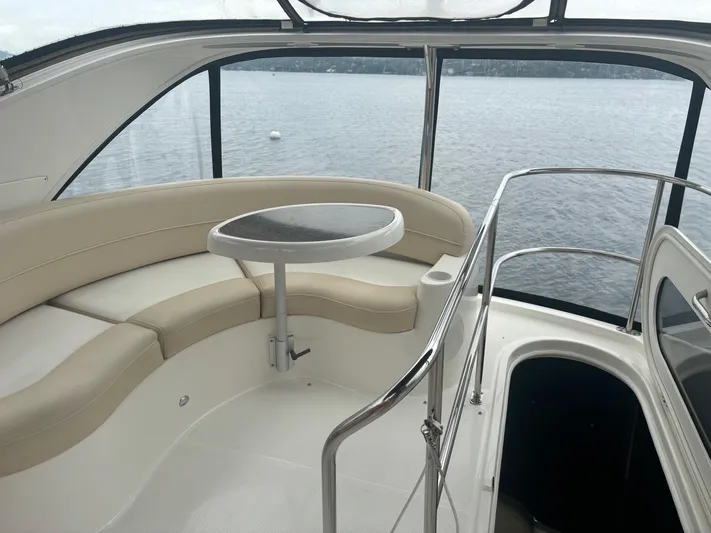 Psalm Waters Yacht Photos Pics 2012 Meridian 341 Sedan Bridge interior with curved seating and table, overlooking water.