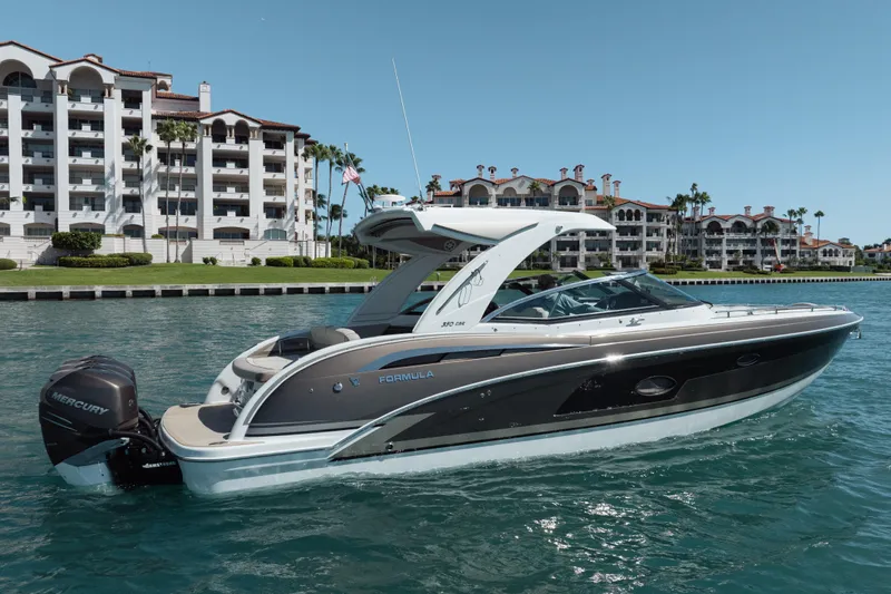 Knot Again Yacht Photos Pics 2018 Formula 350 Crossover Bowrider OB on water near luxury waterfront buildings.
