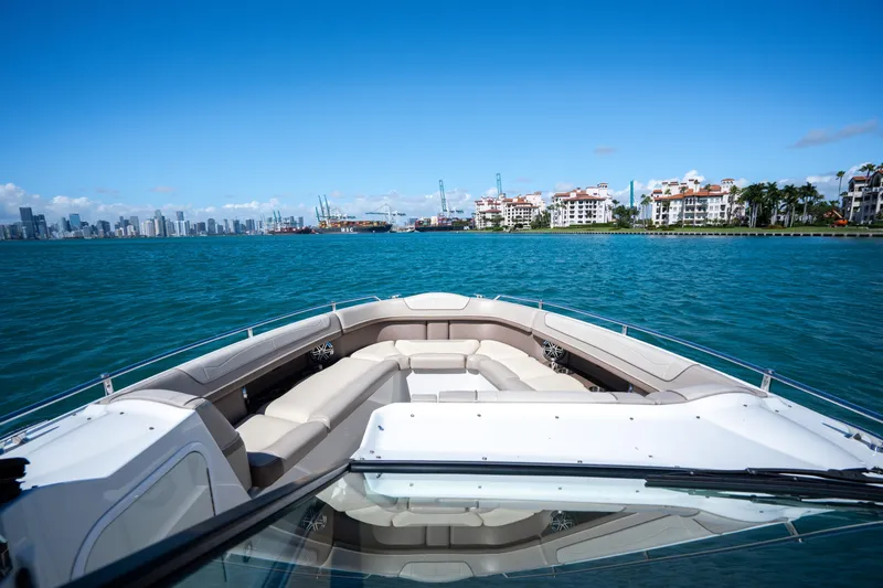 Knot Again Yacht Photos Pics 2018 Formula 350 Crossover Bowrider OB cruising near city skyline and waterfront buildings.