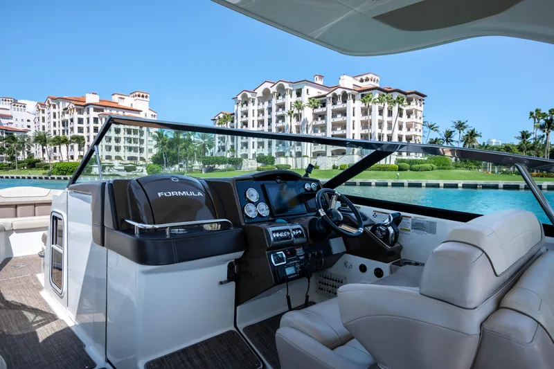 Knot Again Yacht Photos Pics 2018 Formula 350 Crossover Bowrider OB interior with waterfront view and luxury buildings.