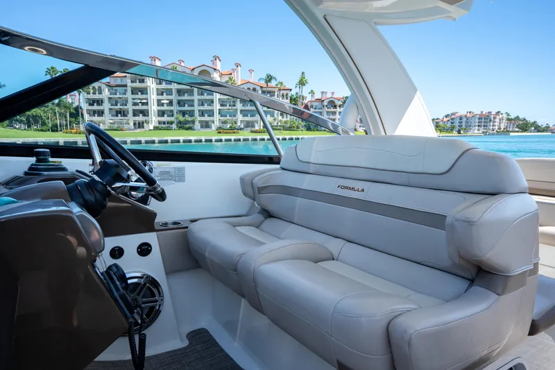 Knot Again Yacht Photos Pics 2018 Formula 350 Crossover Bowrider OB interior with luxurious seating, overlooking waterfront buildings.