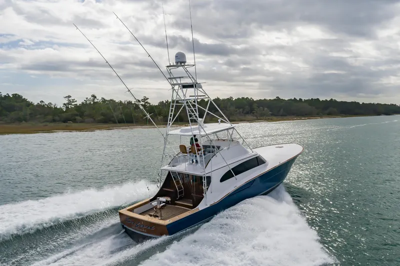 Safari Yacht Photos Pics 1997 Garlington 61 yacht cruising on a scenic waterway under cloudy skies.