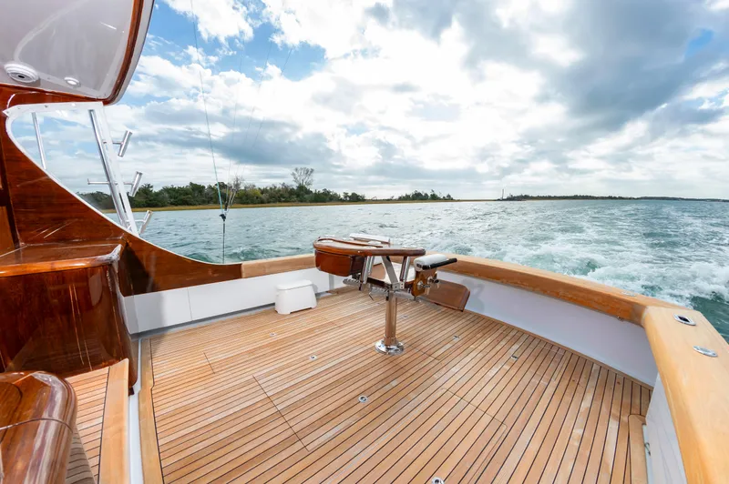 Safari Yacht Photos Pics Luxurious 1997 Garlington 61 yacht with wooden deck, cruising on open water under cloudy skies.