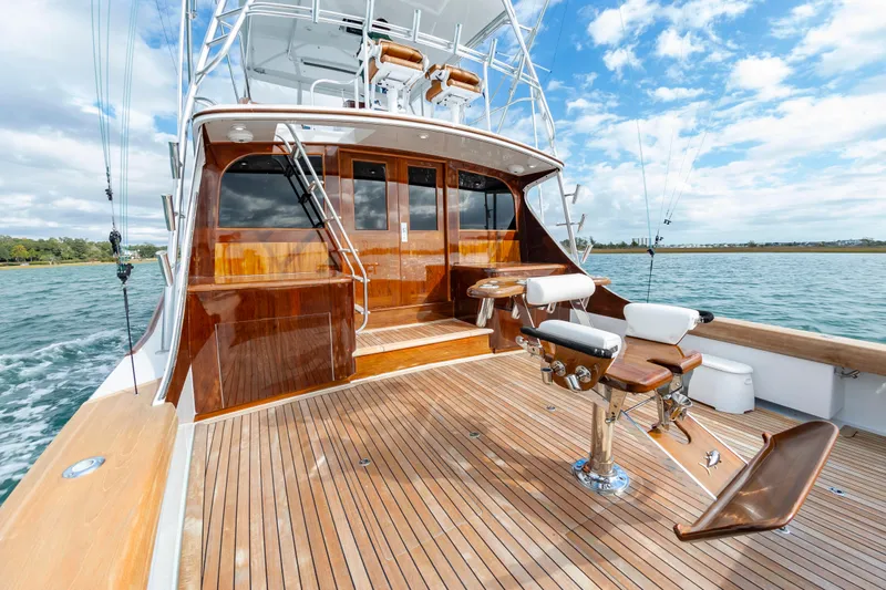 Safari Yacht Photos Pics Luxurious 1997 Garlington 61 yacht with wooden deck and fishing chairs on open water.