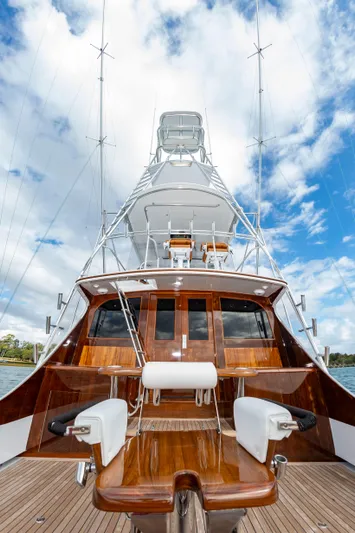 Safari Yacht Photos Pics Luxurious 1997 Garlington 61 yacht with polished wood deck and fishing chairs under a cloudy sky.
