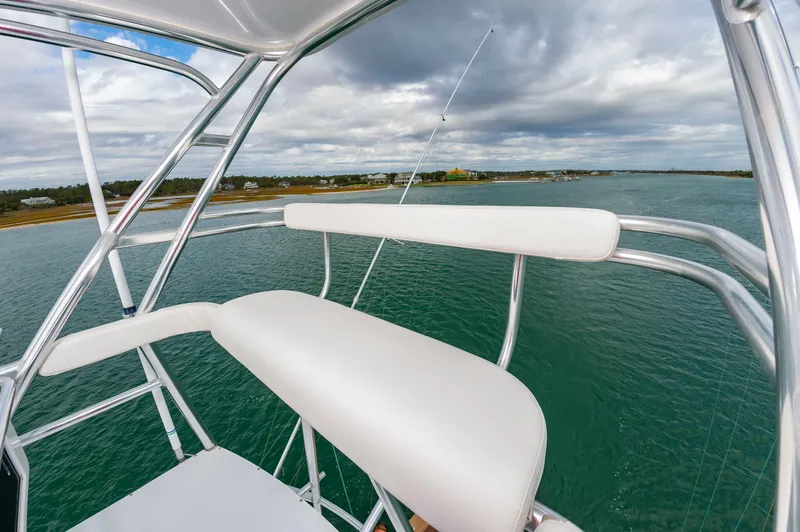 Safari Yacht Photos Pics 1997 Garlington 61 boat with white seating, overlooking calm waters and cloudy sky.