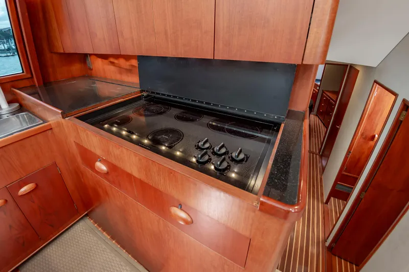 Safari Yacht Photos Pics Kitchen area in a 1997 Garlington 61 yacht with wooden cabinetry and electric stove.