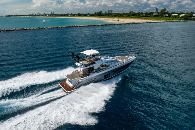  Yacht Photos Pics 2021 Azimut S6 Sportfly yacht cruising near a scenic coastline.