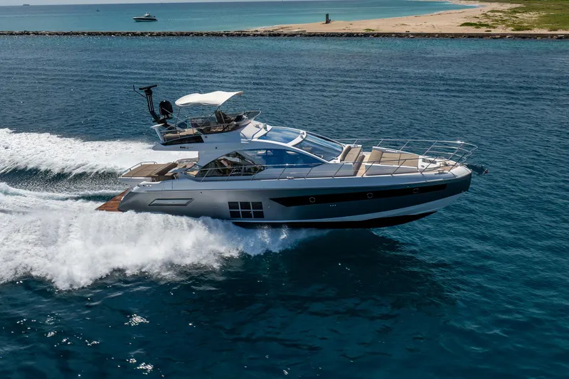  Yacht Photos Pics Azimut S6 Sportfly 2021 yacht cruising on open water near a sandy coastline.