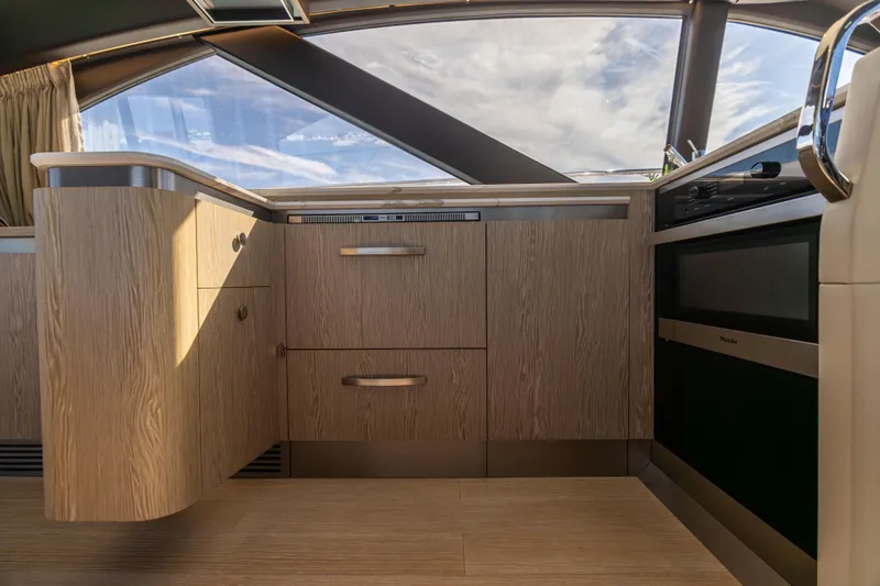  Yacht Photos Pics Modern kitchen interior of 2021 Azimut S6 Sportfly yacht with wood cabinetry and sleek appliances.