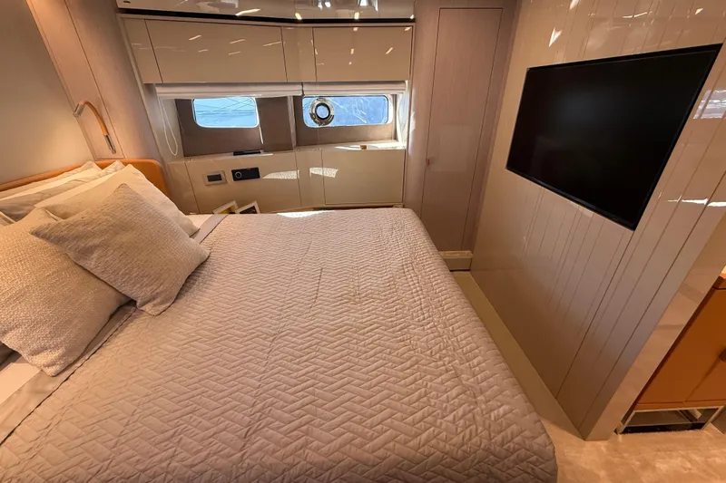  Yacht Photos Pics Luxurious bedroom interior of 2026 Cranchi 62 yacht with modern decor and large TV.
