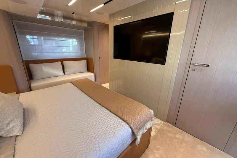  Yacht Photos Pics Luxurious bedroom interior of 2026 Cranchi 62 yacht with modern decor and large TV.