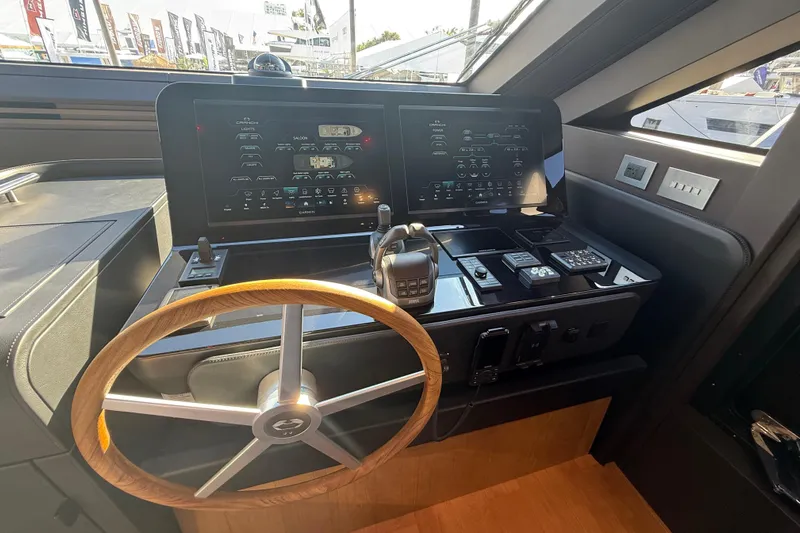  Yacht Photos Pics Helm of 2026 Cranchi 62 yacht with modern controls and wooden steering wheel.
