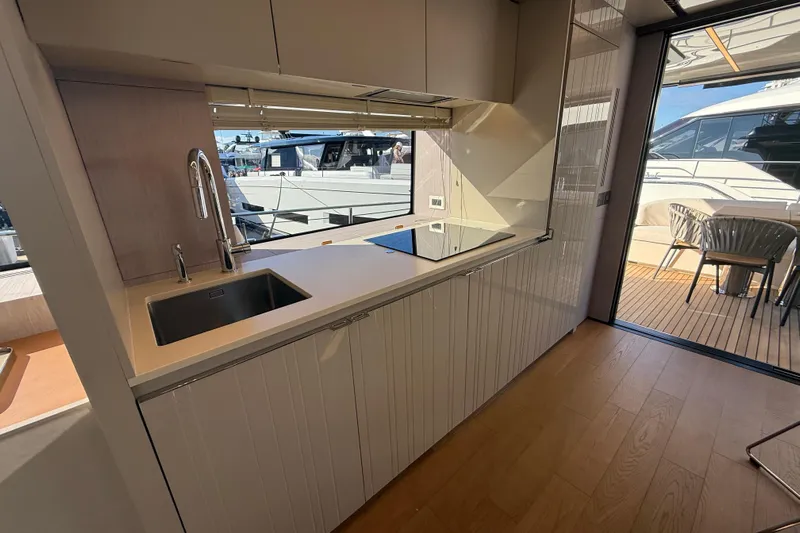  Yacht Photos Pics Modern kitchen interior on 2026 Cranchi 62 yacht, featuring sleek design and outdoor view.