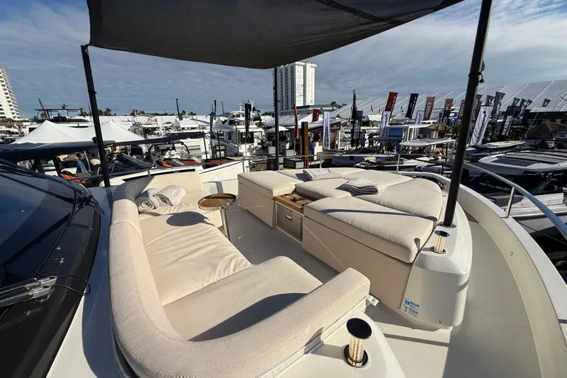  Yacht Photos Pics Luxurious 2026 Cranchi 62 yacht with elegant outdoor seating at a boat show.