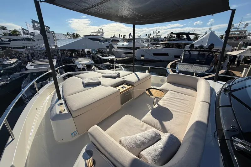  Yacht Photos Pics Luxurious 2026 Cranchi 62 yacht with elegant outdoor seating at a boat show.