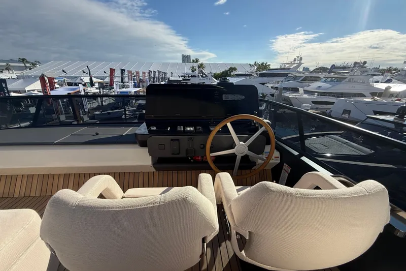  Yacht Photos Pics Helm of 2026 Cranchi 62 yacht with dual seats and wooden steering wheel.