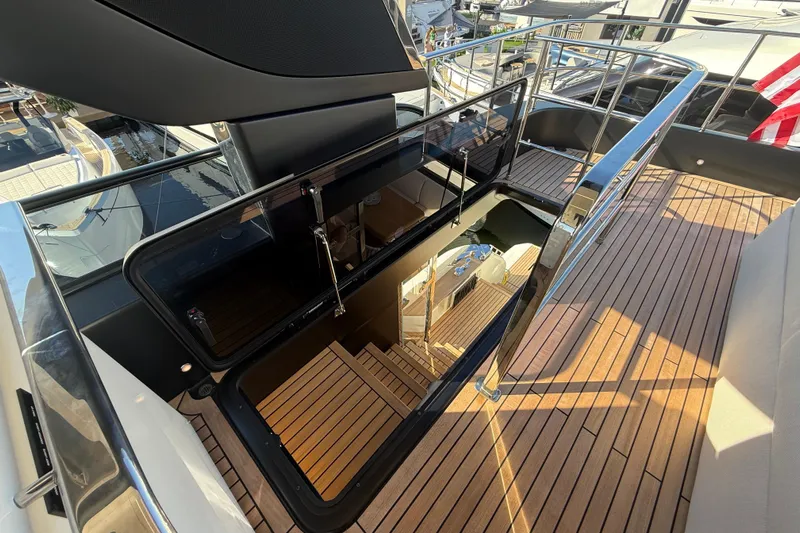  Yacht Photos Pics Luxurious 2026 Cranchi 62 yacht deck with sleek wooden flooring and modern railing design.
