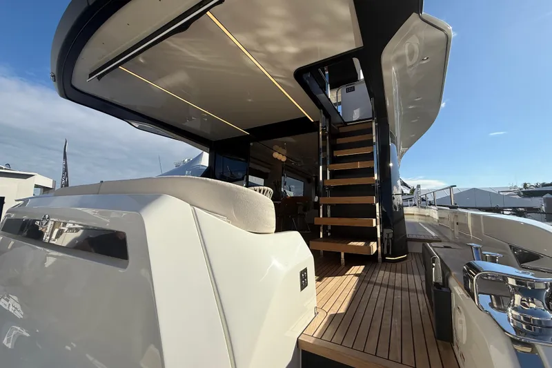  Yacht Photos Pics Luxurious 2026 Cranchi 62 yacht with elegant wooden deck and modern staircase.