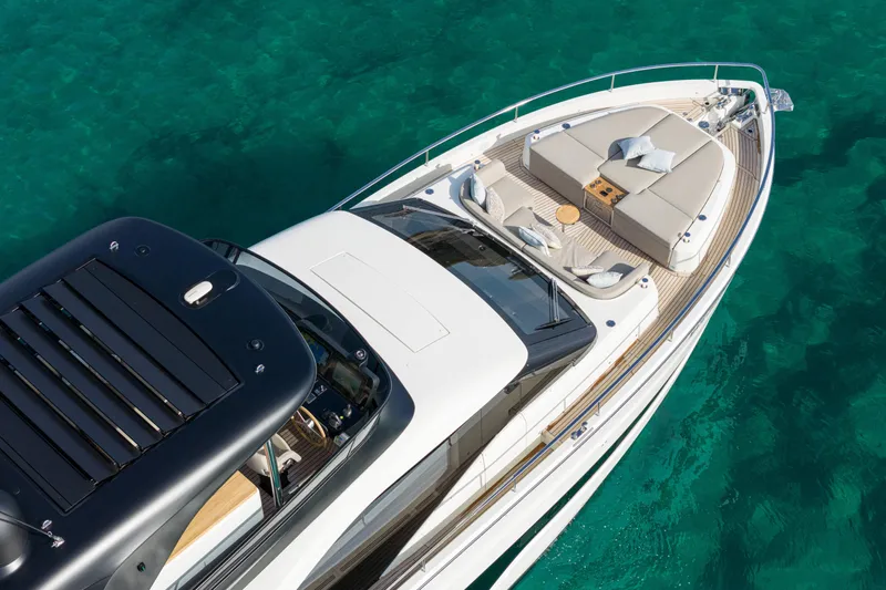  Yacht Photos Pics 2026 Cranchi 62 Sessantadue yacht on clear turquoise water, featuring luxurious deck seating.