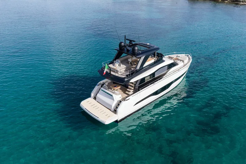  Yacht Photos Pics 2026 Cranchi 62 Sessantadue yacht on clear blue water, rear view.