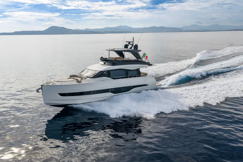  Yacht Photos Pics 2026 Cranchi 62 Sessantadue yacht cruising on open water, scenic mountain backdrop.