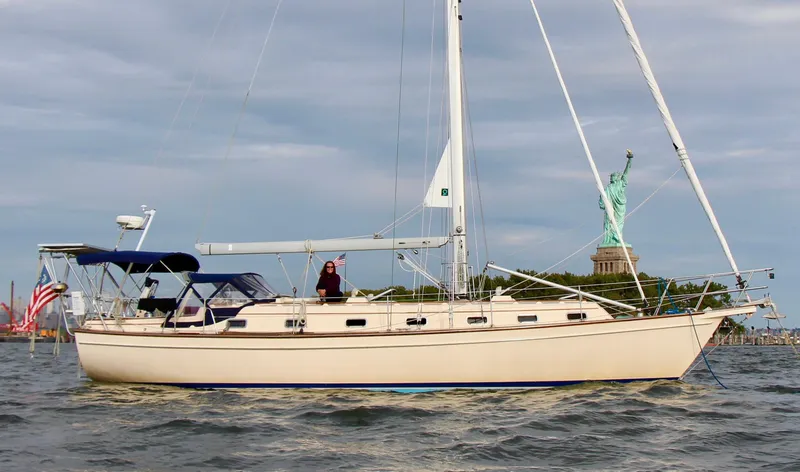 Wonderwind Yacht Photos Pics 1999 Island Packet 45 sailboat near Statue of Liberty, clear sky, calm waters.