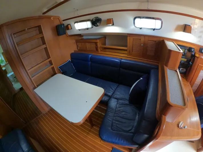 Wonderwind Yacht Photos Pics Interior of 1999 Island Packet 45 sailboat with blue seating and wooden cabinetry.