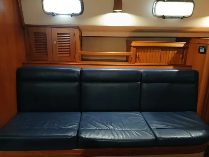 Wonderwind Yacht Photos Pics Interior of 1999 Island Packet 45 yacht with blue leather seating and wooden cabinetry.