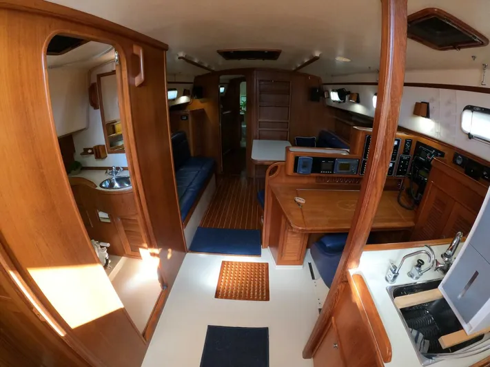 Wonderwind Yacht Photos Pics Interior of a 1999 Island Packet 45 sailboat, featuring wood finishes and a compact kitchen area.
