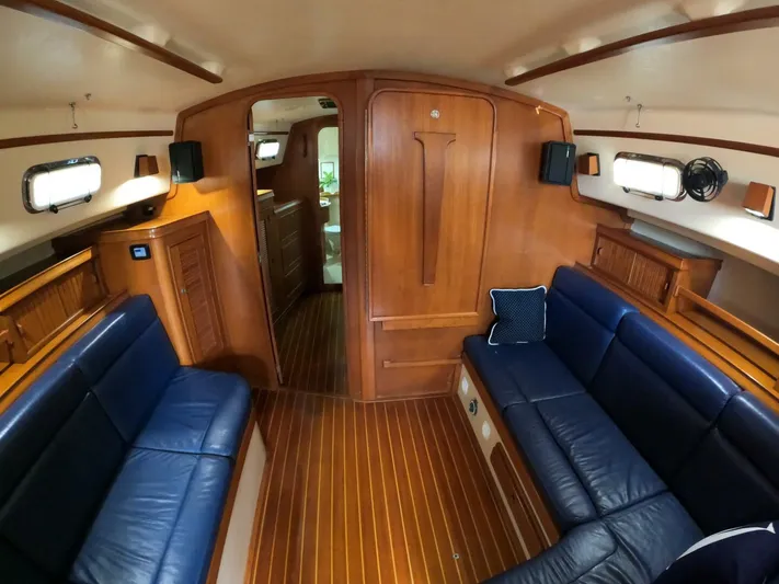 Wonderwind Yacht Photos Pics Interior of 1999 Island Packet 45 yacht with blue leather seating and wooden finishes.