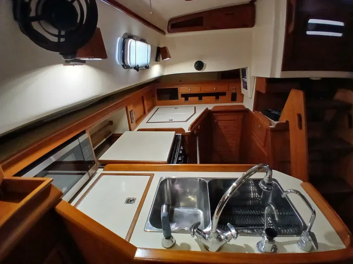 Wonderwind Yacht Photos Pics Interior of 1999 Island Packet 45 yacht, featuring a well-equipped kitchen with sink and stove.