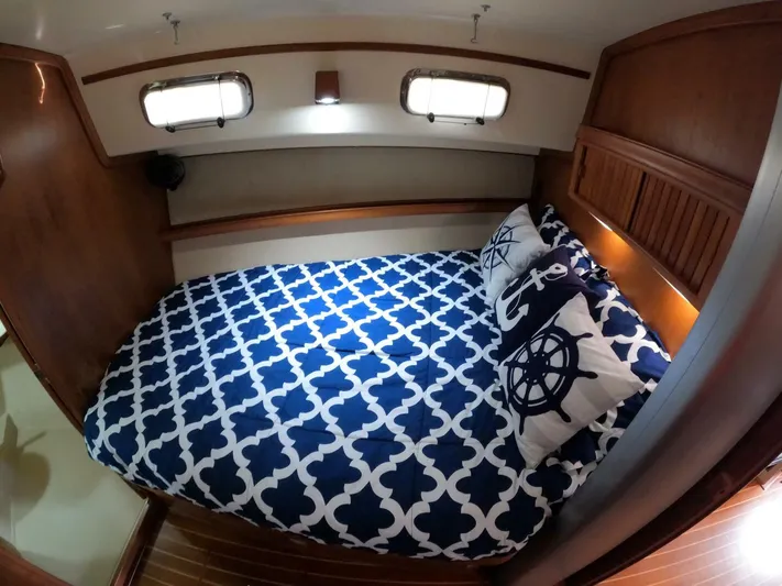 Wonderwind Yacht Photos Pics Cozy cabin interior of 1999 Island Packet 45 with nautical-themed bedding.
