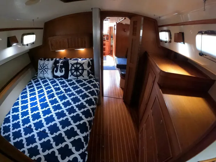 Wonderwind Yacht Photos Pics Cozy cabin interior of 1999 Island Packet 45 sailboat with nautical-themed bedding.