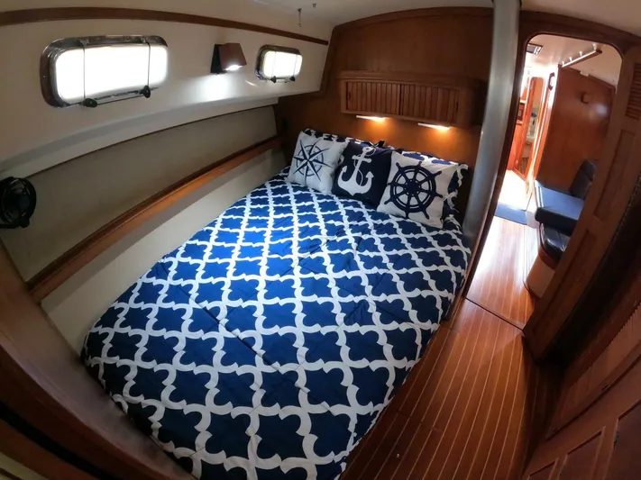 Wonderwind Yacht Photos Pics Cozy cabin interior of 1999 Island Packet 45 sailboat with nautical-themed bedding.