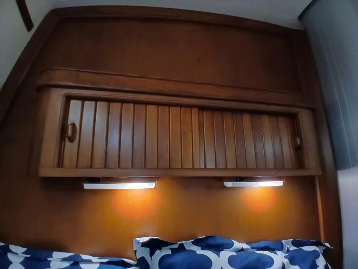 Wonderwind Yacht Photos Pics Wooden cabin interior of 1999 Island Packet 45 yacht with cozy bedding and lighting.