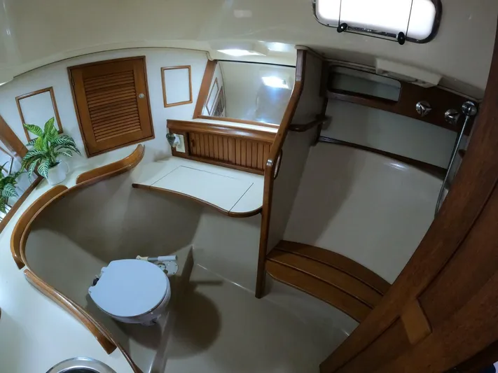 Wonderwind Yacht Photos Pics Interior of 1999 Island Packet 45 yacht, featuring a bathroom with wooden accents and porthole.