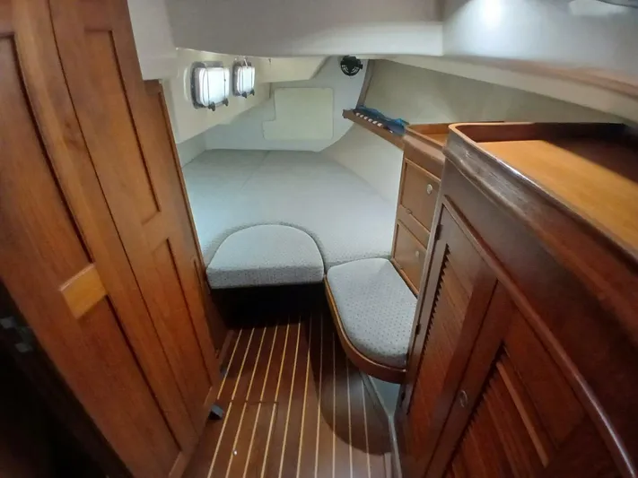 Wonderwind Yacht Photos Pics 1999 Island Packet 45 yacht interior cabin with wooden furnishings and cozy bed.