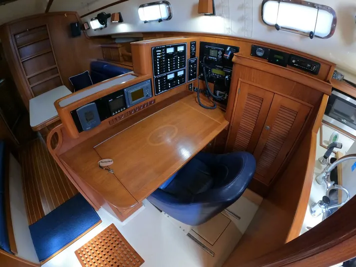 Wonderwind Yacht Photos Pics Navigation station inside 1999 Island Packet 45 yacht, featuring control panels and seating.